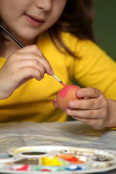 Girl painted Easter eggs at the table