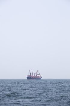 Large cargo ship Boats moored in the sea to make sense compared to the coast.