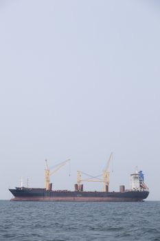 Large cargo ship Boats moored in the sea to make sense compared to the coast.