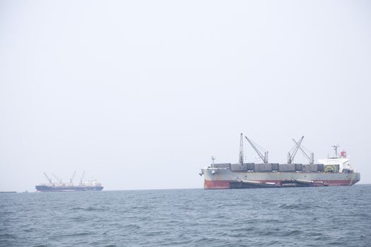 Large cargo ship Boats moored in the sea to make sense compared to the coast.