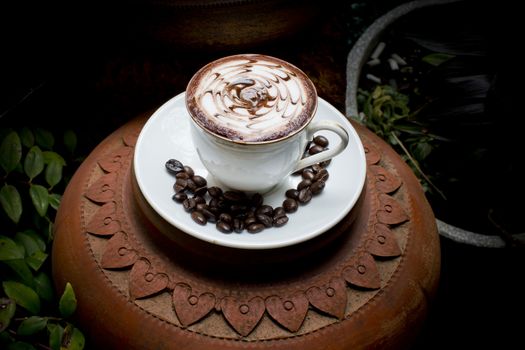 Art latte on hot coffee with coffee beans.