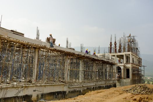 Construction site with workers on sky background