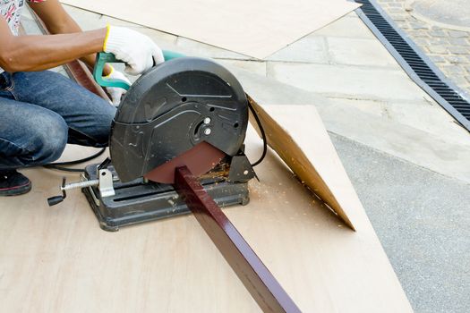 Worker cutting metal with grinder.