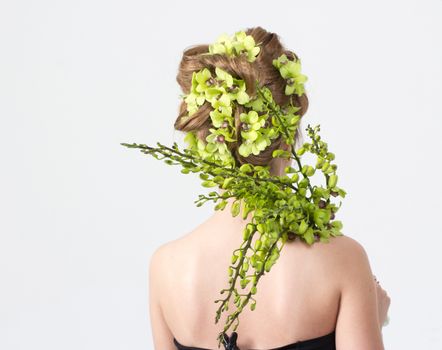 Beautiful woman with orchid flower in hair posing