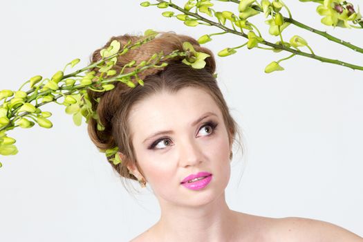 Beautiful woman with orchid flower in hair posing