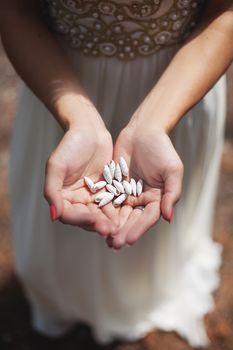 Woman holding small shell in her hands.