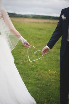 Wedding day. Bride and groom outdoor portrait with white heart.