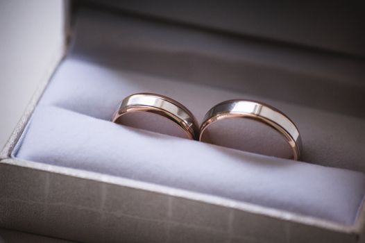 two wedding rings in grey box with bow