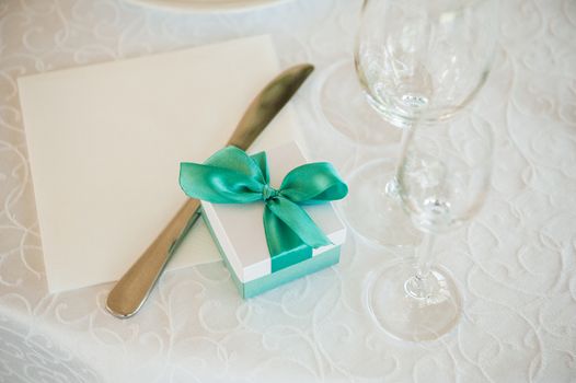 wedding gift box with green bow on table 