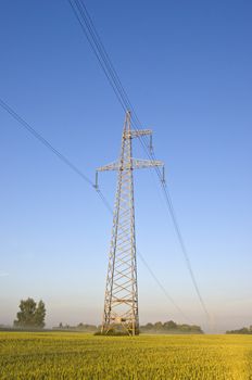 electricity high voltage metal pole construction on summer farmland field