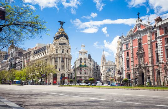 Madrid, Spain - May 6, 2012: Metropolis Building (Edificio Metropolis) and Grassy Building (Edificio Grassy) famous Beaux-Arts style of Madrid and San Jose church, Spain
