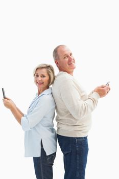 Happy mature couple using their smartphones on white background