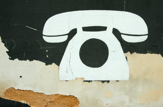 White symbol of big phone painted on old wall.