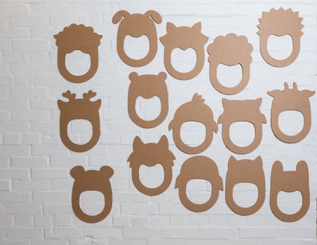 Set of cardboard masks on a white brick wall. Consept card.