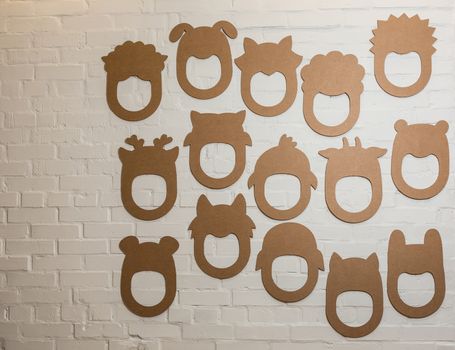 Set of cardboard masks on a white brick wall. Consept card.