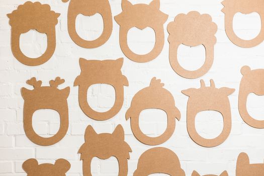 Set of cardboard masks on a white brick wall. Consept card.