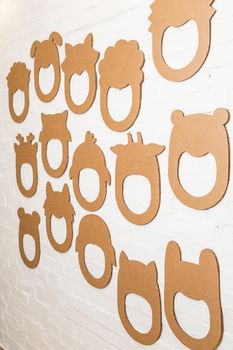 Set of cardboard masks on a white brick wall. Consept card.