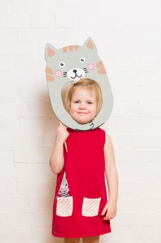 Little blonde girls holding cat mask on white background