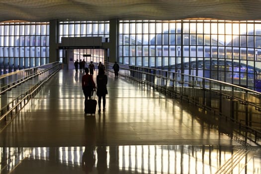 HONG KONG, S.A.R., CHINA - JENUARY 29, 2014: Passengers in the airport main lobby on Jenuary 29, 2014 in Hong Kong, China. The Hong Kong airport handles more than 70 million passengers per year.