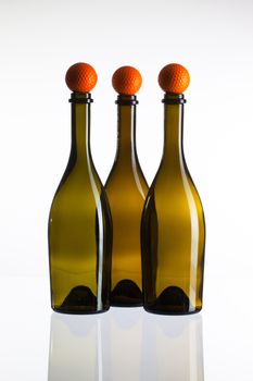 Empty three  wine bottles and golf balls on a glass desk
