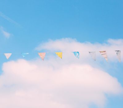 Colorful bunting flags on blue sky with retro filter effect