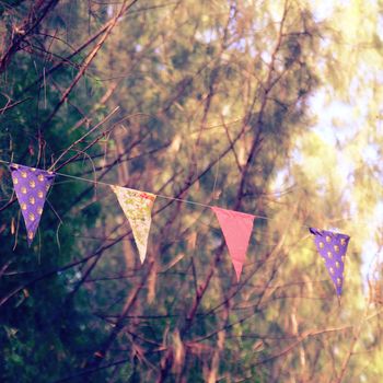 Colorful bunting flags hanging on tree with retro filter effect