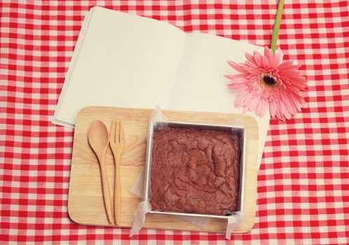 Homemade brownie on blank notebook with retro filter effect