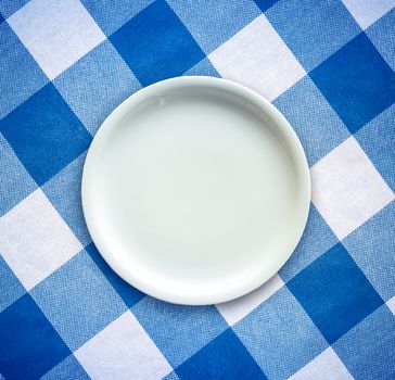 Retro Filtered Empty White Plate On A Checked Table Cloth