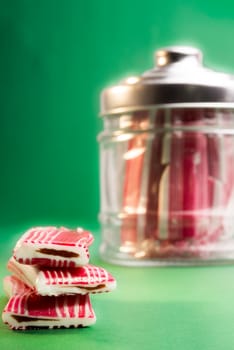 Candy on a green background, with the bottle in the background.