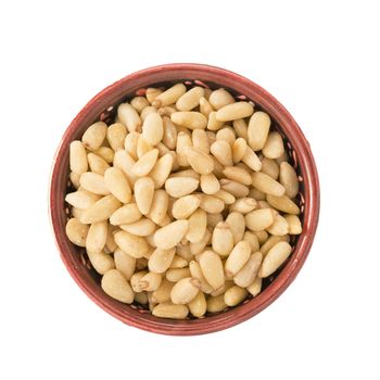 Bowl of pine nuts isolated on a white background