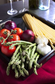 Asparagus, tomatoes,onions garlic, and linguini for making an Italian linguini meal