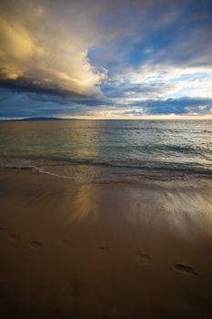 Footprints in sand during sunrise on Maui in Hawaii