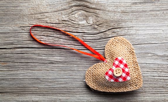 Heart shaped decoration made of wood, over wooden background