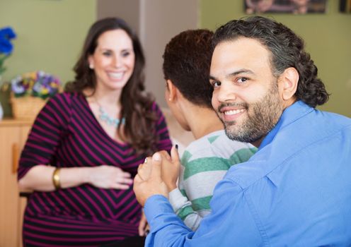 Smiling Latino man with wife and surrogate mother