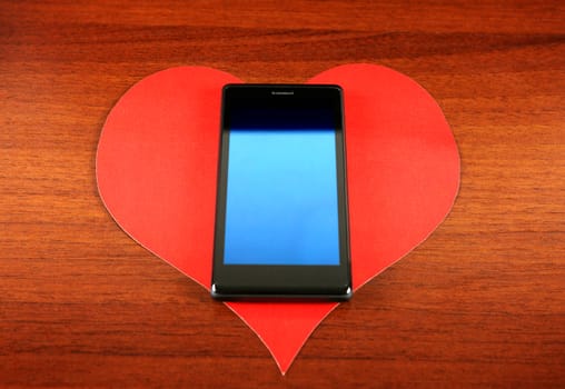 Heart Shape and Cellphone on the Wooden Background