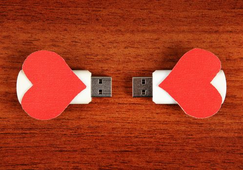 Two USB Flash Drive with Heart Shapes on the Wooden Background