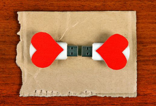 Two USB Flash Drive with Heart Shapes on the Wooden Background