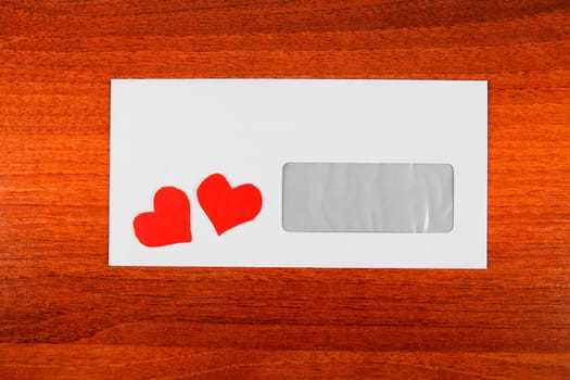Envelope with a Heart Shapes on the Wooden Background