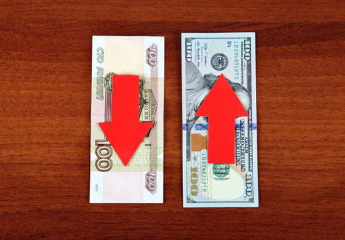 Concept of Ruble Down and Dollar Grow on the Wooden Background