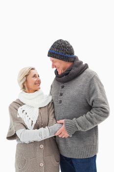 Happy mature couple in winter clothes on white background