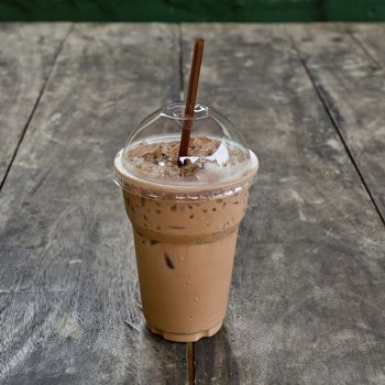 Cold coffee drink with ice on old wood table