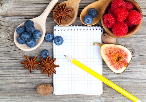 top view of recipe book with ingredients on wooden table