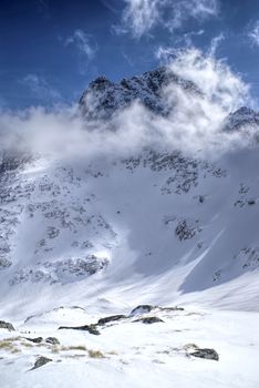 Picturesque view of sun illuminating snowy slopes in high mountains                   