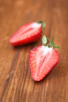 ripe strawberry is bisected, on a wooden background