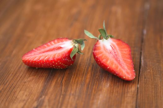 ripe strawberry is bisected, on a wooden background