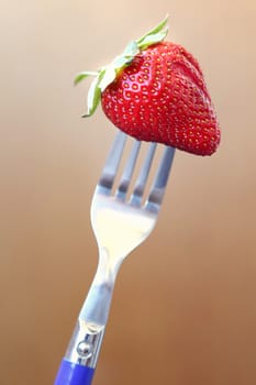 fresh ripe red strawberry on metallic fork