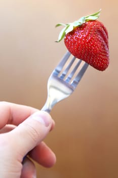 fresh ripe red strawberry on metallic fork