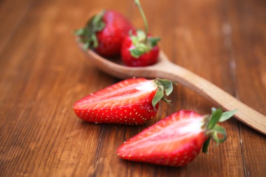 ripe strawberry is bisected, on a wooden background