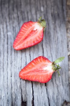 ripe strawberry is bisected, on a wooden background