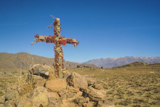 Christian cross on peruvian arid landscape near Canon del Colca
